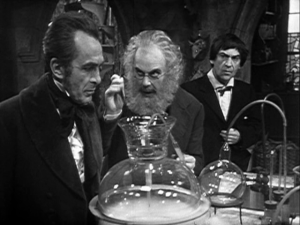 The Doctor looks on as Edward Waterfield and Theodore Maxtible discuss their experiment