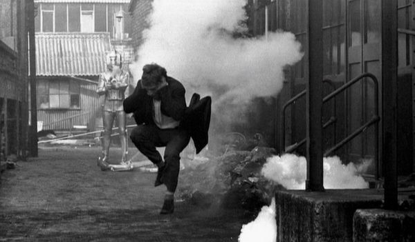 The Doctor protects his hearing as he runs from a Cyberman