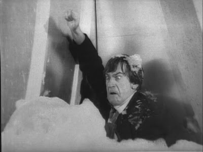 The Doctor is covered in foam as he attempts to gain entry to the Weather Station